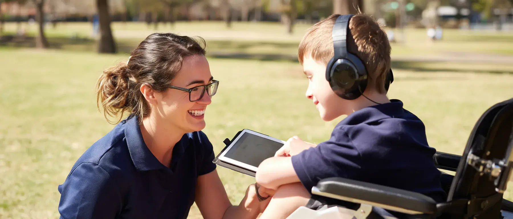 A behaviour support practitioner working with a young participant outdoors