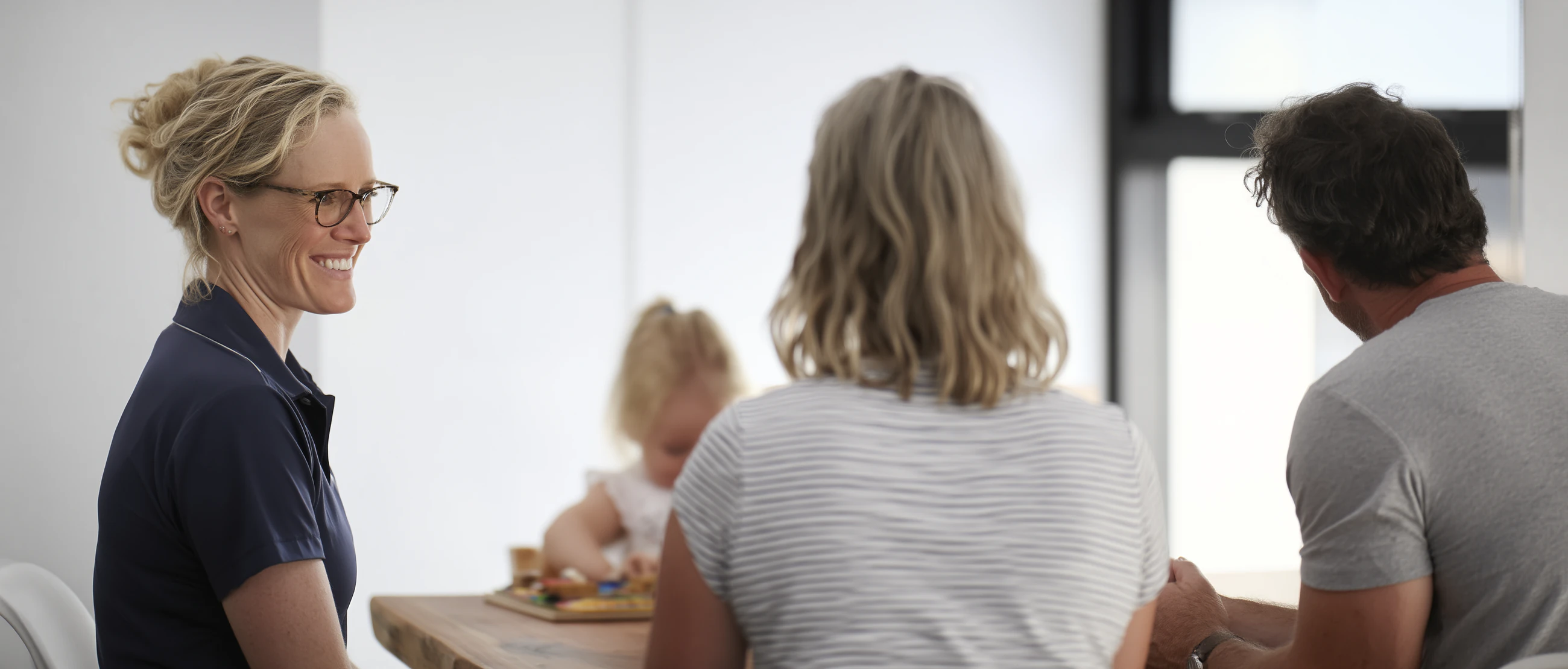 A behaviour support practitioner meeting with a participant and family